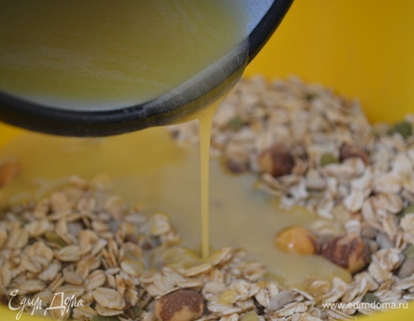 В сотейнике соединить сливочное масло и мед, растопить. Влить к хлопьям, перемешать.