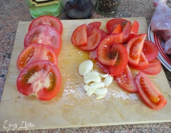 У помидоров вырезать 4 больших кружочка (по 2 с каждой стороны), а остальные части крупно нарезать. Чеснок раздавить и порубить.