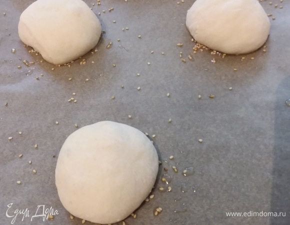 Застелите 2 противня пергаментной бумагой. Из этого количества теста получаются 6 лепешек. На каждый противень нанесите по 3 «кляксы» оливкового масла и посыпьте кунжутом. Подошедшее тесто разделите на 6 равных частей. Каждую скатайте в шарик и выложите на кунжут. Накройте и оставьте на 20 минут на отдых.
