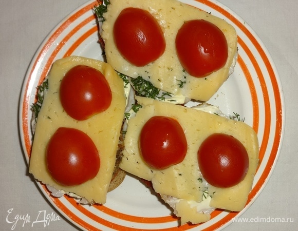 Выложить помидоры на сыр. Поставить бутерброды в духовку или микроволновку на 2–3 минуты для расплавления сыра.