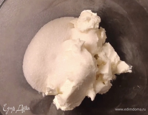 В глубокой миске соедините сливочный сыр и сахар с ванилью венчиком. Перемешивайте до однородного состояния. Здесь нельзя пользоваться миксером, иначе масса взобьется и чизкейк будет слишком рыхлым.