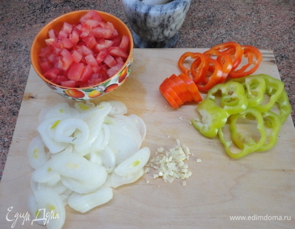 Нарежьте болгарский перец кольцами (лучше выбрать разных цветов — это выглядит красочнее). Лук нарезать полукольцами, чеснок мелко нарубить. Помидоры очистить от кожицы и нарезать кубиками.