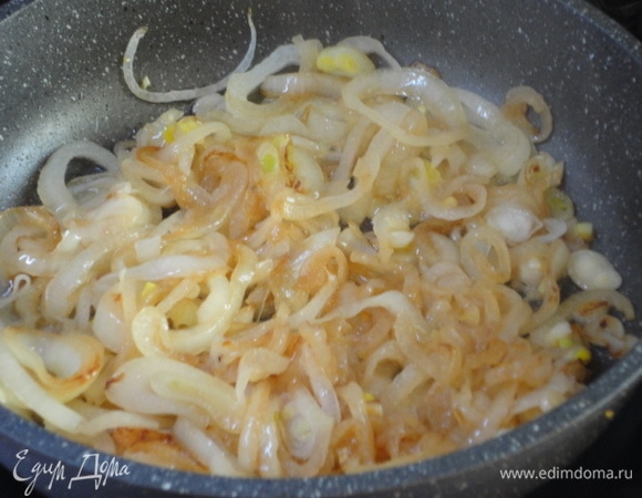 В этой же сковороде, где обжаривали индейку, обжарить лук до золотистого цвета и переложить в форму для запекания поверх индейки.