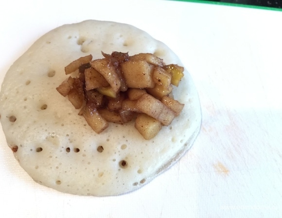 Выкладывайте блинчик на доску. Сверху положите 1 ст. л. начинки и защипните кулечком. Краешки очень легко соединяются.