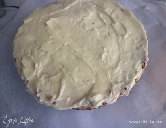 Положить на бумагу для выпечки один корж, нанести на него белый крем, оставить от него 1 ст. л. для оформления верха торта.