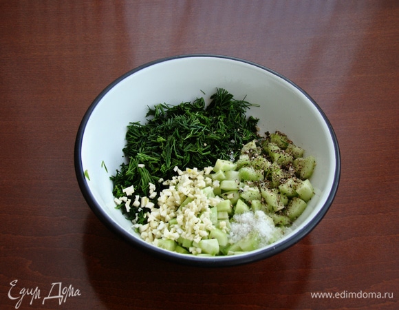 В миске смешать огурцы, зелень и чеснок, посолить, поперчить и оставить минут на 10.