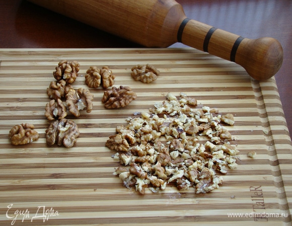 Грецкие орешки измельчить: прокатать скалкой или просто порубить ножом.