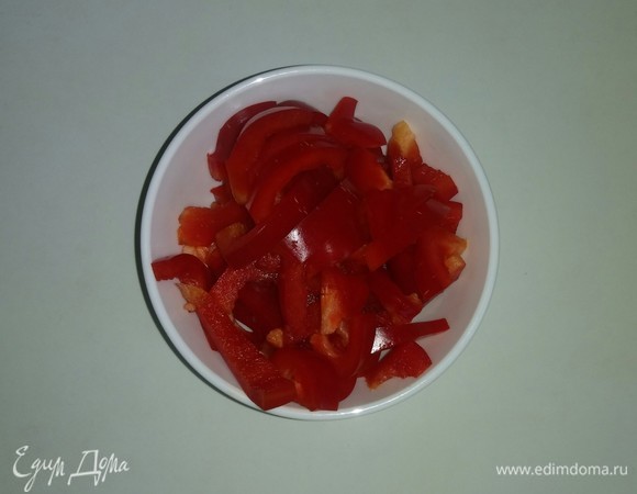 Болгарский перец очищаем от семян и перегородок. Затем разрежем его пополам, после чего режем его полосками.