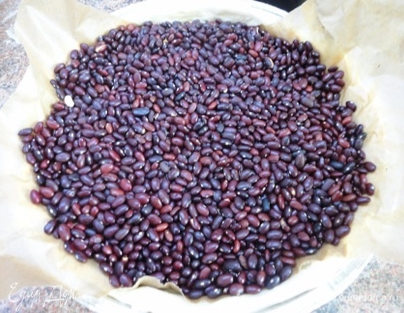 Застелить пекарской бумагой и засыпать «дежурной» крупой. Выпекать 15 минут при температуре 200°C. Затем крупу бумагой удалить, а корж еще подержать в духовке минут 10, чтобы он пропекся. Дать остыть.