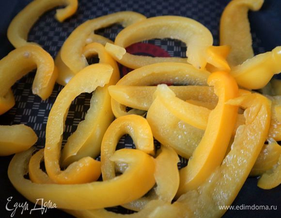 Духовку разогреть до 200°C. Желтый болгарский перец очистить от семенной части, нарезать на полоски, припустить в сотейнике, закрытом крышкой, в небольшом количестве воды почти до готовности, воду слить, перец просушить. Помидоры (здесь 2 небольших помидора) нарезать тонкими колечками.