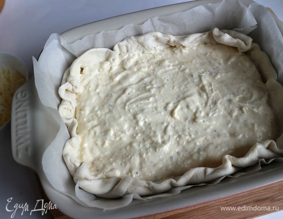 Поместить на тесто равномерно сырную смесь и часть натертого на крупной терке сыра (примерно половину).