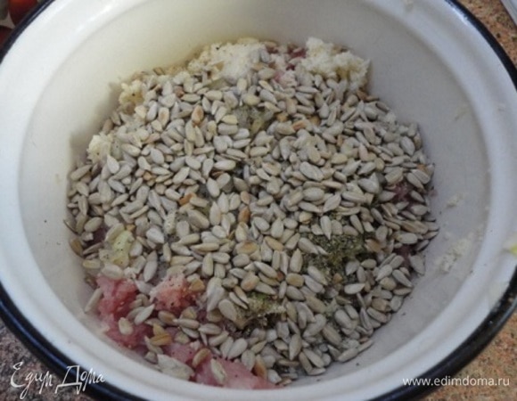 Хлеб отжать и добавить в фарш. Сюда же добавить большую часть семечек (немного оставьте для посыпки), майоран, остывшие лук с чесноком. Все посолить, поперчить и вымесить фарш.