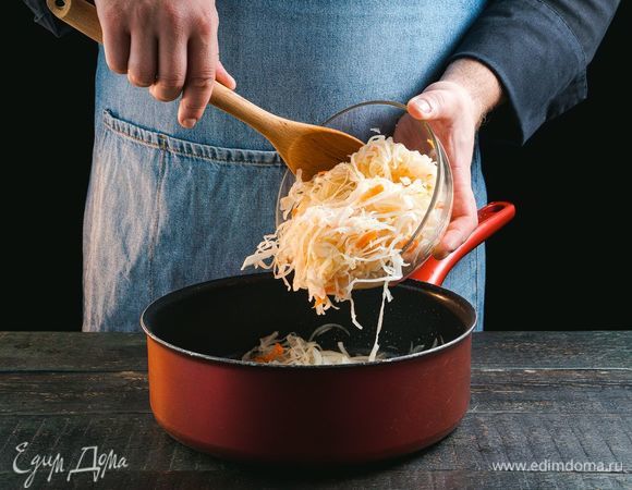 При необходимости слегка промойте квашеную капусту, отожмите. Добавьте капусту в сковороду к луку.