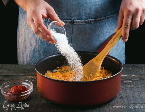 За несколько минут до готовности добавьте к капусте сахар и томатную пасту, все перемешайте. Потушите еще пару минут.