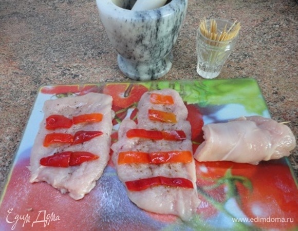 Перец нарезать на полоски, лук — на мелкие кубики. Тмин истолочь в ступке. Шницели отбить, посолить, посыпать тмином, разложить полоски перца и свернуть рулетиком. Закрепить.