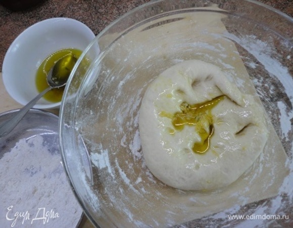 Добавить к тесту соль, вымесить. Продолжая месить, частями добавлять к тесту масло с чесноком. Месить 10–15 минут. Оставить накрытым подходить примерно на 1 час.