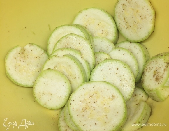 Нарезаем кружочками кабачки, солим и перчим их.