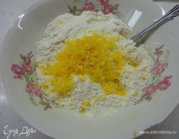 Натрите цедру со всего лимона и выжмите весь сок. Смешайте муку, соду и лимонную цедру. Включите духовку на разогрев до 180°C и приготовьте форму диаметром 20 см, выстлав ее бумагой и смазав маслом.