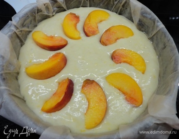 Вылейте тесто в подготовленную форму, сверху уложите дольки персика и выпекайте 35–40 минут. Проверяйте готовность деревянной шпажкой.