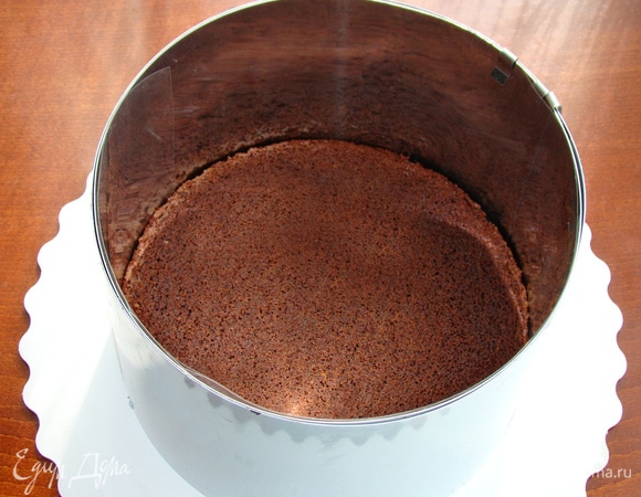 Бисквит установить на блюдо, поместить в кондитерское кольцо и проложить ацетатной пленкой. Бисквит получается в меру влажным, поэтому дополнительной пропитки не требуется.