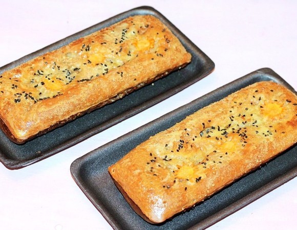 Затем смазываем пироги желтком, взбитым с 1 ст. л. молока и щепоткой сахара, и дорумяниваем в духовке (примерно 2–3 минуты). Можно посыпать пироги черным кунжутом или тмином — это по желанию.