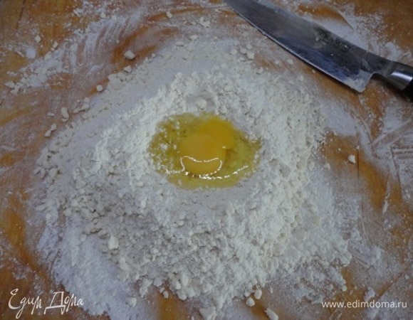 Собрать горкой, добавить сметану и яйцо. Быстро замесить тесто, завернуть его в пищевую пленку и положить в холодильник на 30 минут.