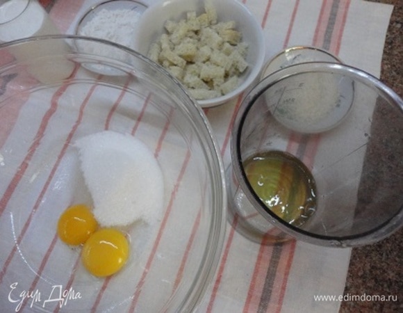 Включить духовку на разогрев до 180–190°C. Белый хлеб без корочки (или белые булки, батоны и т. п.) нарезать небольшими кубиками. Разделите желтки и белки. Да, яйца у меня были крупные, но об этом в рецепте не говорится. Желтки взбить с сахаром и ванильным сахаром, мукой и сливками, чтобы не было комочков. Добавьте ликер (у меня был лимончелло) по желанию.