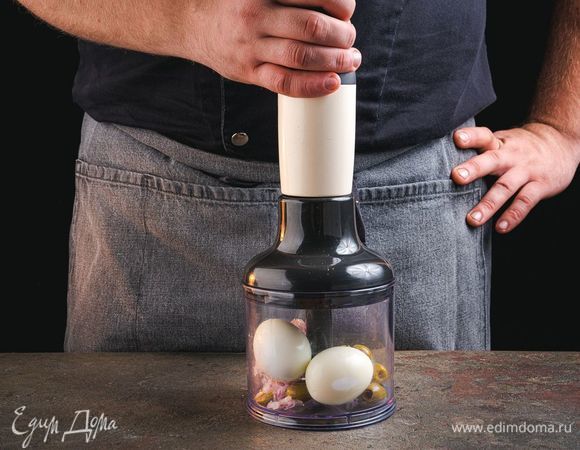 В чашу блендера выложите оливки, лук, куриные яйца и зелень. Взбейте все до однородного состояния.