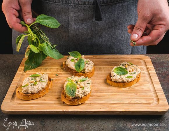 Выложите тапенаду на зерновой хлеб, украсьте поджаренными кедровыми орехами, базиликом и тимьяном.