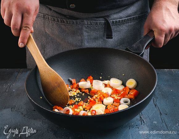 В разогретую сковороду-вок налейте кунжутное масло. Добавьте чеснок, имбирь, порей и перец. Потушите несколько минут.