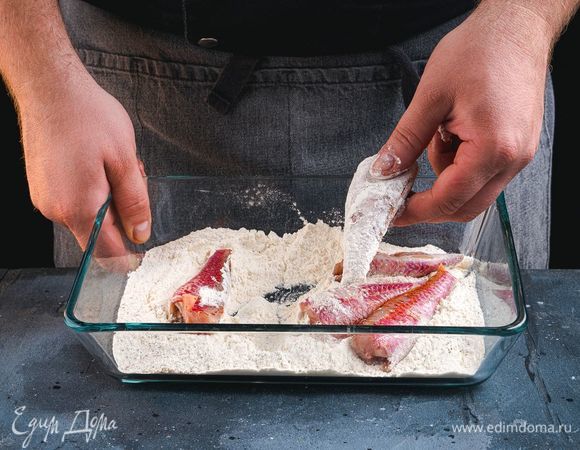 Смешайте муку с черным перцем и солью. Обваляйте куски рыбы в этой смеси.