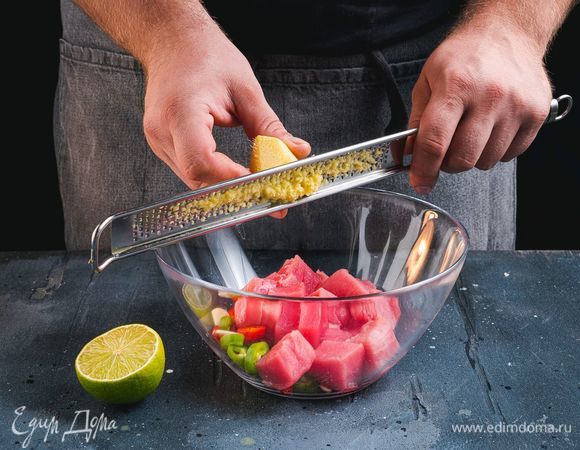 В глубокую миску выложите нарезанные овощи, грейпрут и нарезанную на небольшие кубики рыбу. Имбирь почистите и натрите на терке. Выжмите сок лайма.