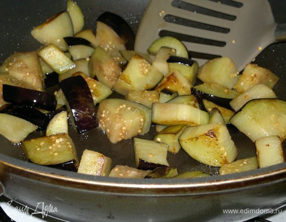 В сковороде разогреть часть растительного масла. Обжарить (частями) кусочки баклажанов до румяности. Выложить баклажаны в кастрюлю.