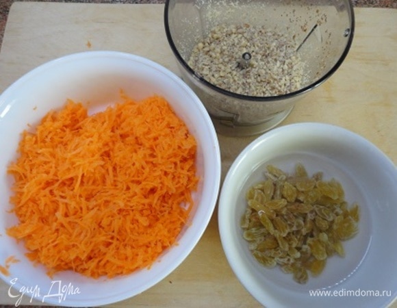 Изюм промыть и замочить в теплой воде. Морковь натрите на мелкой терке.