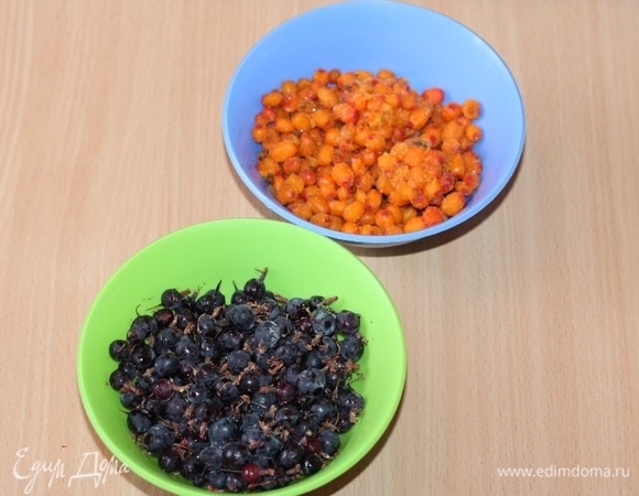 Ягоды промойте, выложите в сито и обсушите. Поочередно измельчите ягоды блендером (облепиху, затем — смородину) и перетрите через сито.
