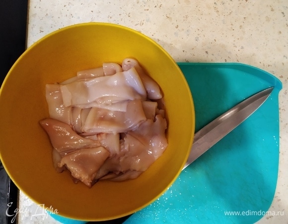 Нарезаем кальмары, надо обвалять их в муке, поперчить и посолить.