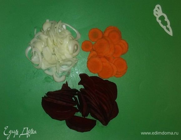 Тонкими кружочками нарезаем морковь. Затем разрезаем свеклу пополам и так же, как и морковь, режем тонко. Репчатый лук режем кольцами, а затем распушаем его руками.