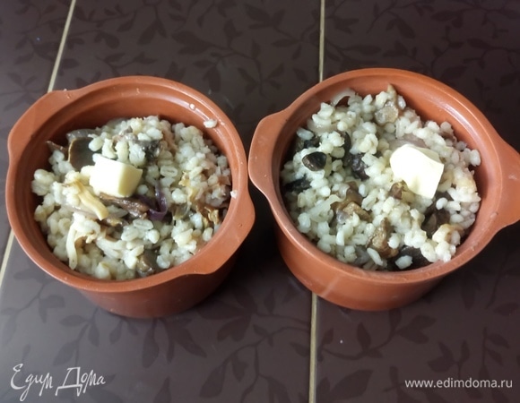 Разложите кашу по горшочкам для запекания, сверху добавьте по маленькому кусочку сливочного масла, накройте крышками и поставьте в заранее разогретую до 180°C духовку на 20 минут для того, чтобы вкусы «подружились». Подавайте перловку горячей в горшочках со свежей зеленью и овощами. Приятного аппетита!