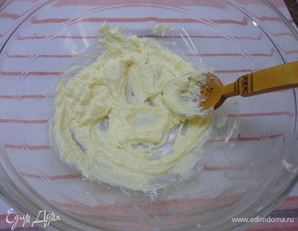Включите духовку на разогрев до 180°C. Масло заранее достаньте из холодильника и позвольте ему размягчиться. Разотрите его с сахаром до состояния крема.