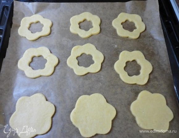 Перенесите их на противень, выстланный пекарской бумагой, и у половины заготовок вырежьте небольшое отверстие цветочком, звездочкой или просто кружочком. Выпекайте 10–15 минут, ориентируйтесь по своей духовке.