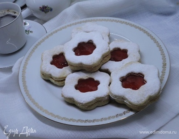 Остывшее печенье соедините попарно, предварительно смазав клубничным или малиновым вареньем (а можно использовать абрикосовый кофитюр или даже тонкий слой масляного крема).