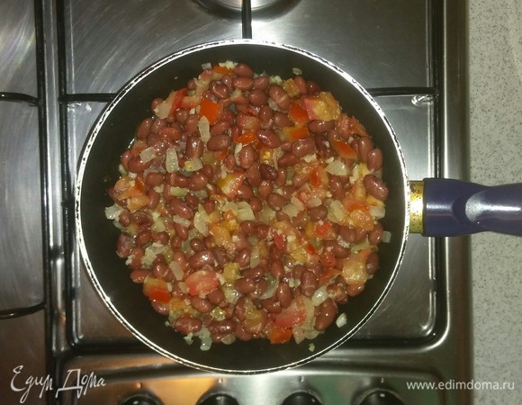 После чего добавляем в сковородку к овощам фасоль. Солим, перчим. Все перемешиваем и тушим под крышкой около 15 минут.