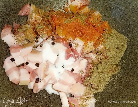 В казан закидываем кусочки шпика, перец горошком, красный и черный молотый перец.