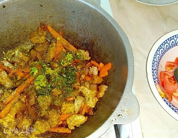 Увеличиваем огонь до максимума. Морковка даст влагу — нужно это влагу испарить, ну и надо именно зажарить морковку и мясо, а не сварить, для этого и делаем максимальный огонь! Когда морковка поджарится, чуть убавляем огонь, добавляем любисток, помидоры поверх его закидываем, чтобы он аромат внутри казана давал, а не всплывал наверх.