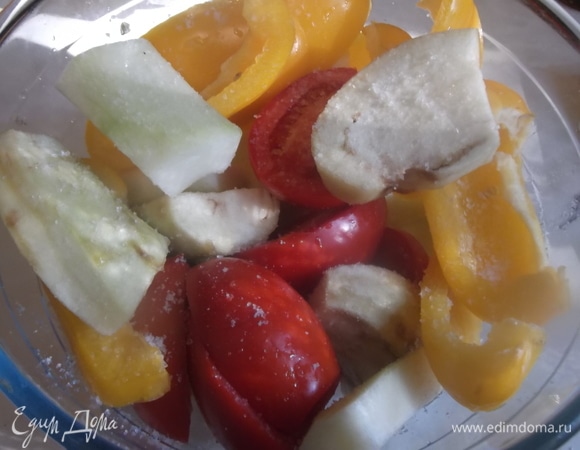 Баклажан и кабачок почистить. У перца удалить семена. У помидоров срезать место плодоножки. Овощи разрезать на крупные сегменты. Посолить.