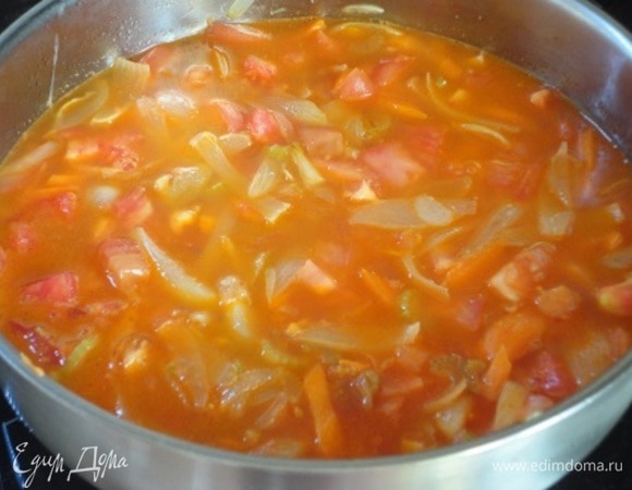 Выложить к овощам томатную пасту и помидоры и влить бульон. Тушить 10–15 минут при открытой крышке.