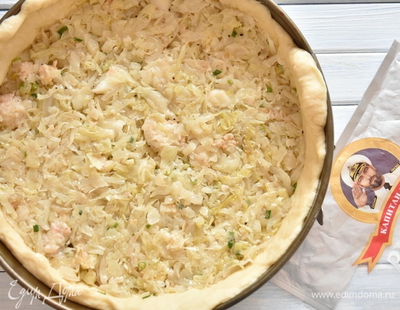 Подошедшее тесто разделить на две неравные части. Большую часть раскатать и распределить по дну и бортам формы для выпечки. Предварительно форму смазать растительным маслом. Поверх теста разложить начинку.