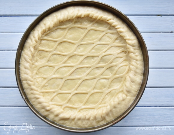 Из оставшейся части теста сформировать верх пирога. Края нижнего и верхнего слоя теста защипнуть. Смазать верх пирога взбитым желтком. Оставить пирог на 30 минут для расстойки. В это время включить и нагреть духовку до 180°C. Выпекать пирог 40–45 минут.