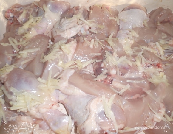 Курицу нарезать на куски. Выложить в форму. Чеснок очистить, натереть на крупной терке. Выложить на курицу.