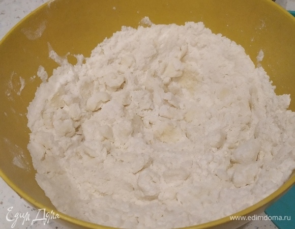 Муку пересыпаем к маслу, добавляем сахар и щепотку соли. Мешал и растирал ложкой. Далее добавляем желток и размешиваем, потом смешиваем воду и сок лимона, понемногу добавляем в тесто и перемешиваем.